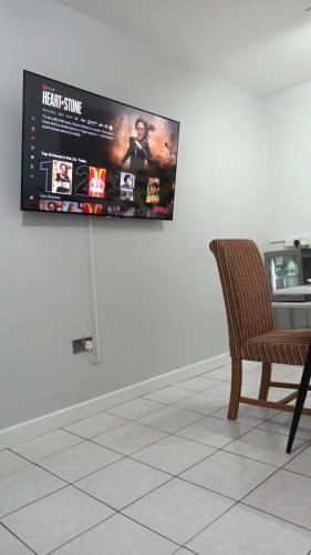 a flat screen tv hanging on a wall at Lister Park Bradford Stylish 1bed Coach House - Quiet & Tranquil Cottage & Parking in Bradford