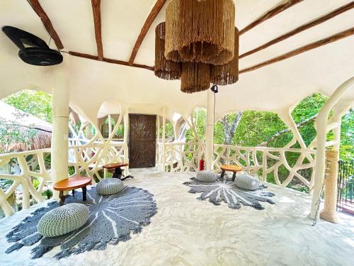 a room with chairs and tables and a ceiling at Ikalar in Akumal