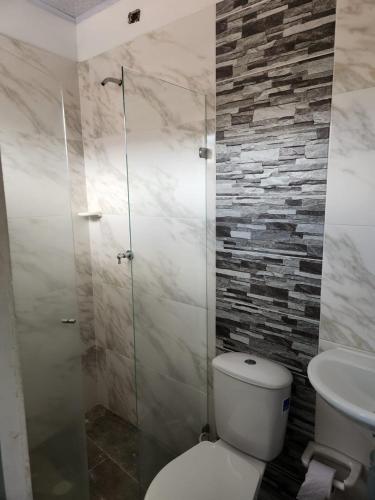 een badkamer met een toilet en een glazen douche bij aparta estudio in Cocorná