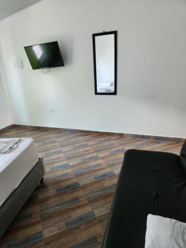 een kamer met een bed en een tv aan de muur bij aparta estudio in Cocorná
