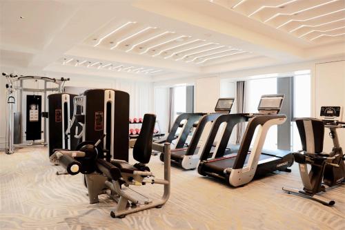 a gym with several treadmills and cardio machines at Holiday Inn Express Qingdao Northern West Coast by IHG in Qingdao