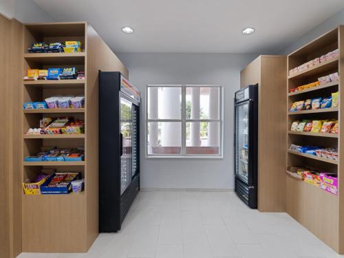 a store aisle with two refrigerators and a window at Holiday Inn Express & Suites Lakeland North I-4 by IHG in Lakeland