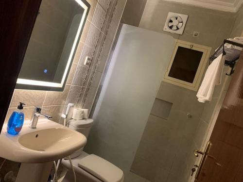a bathroom with a sink and a toilet and a shower at Taibah Apartment in Al Madinah