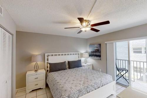 um quarto com uma cama e uma ventoinha de tecto em Beachfront Condo Complex, Heated Pool, Gulfview! em Siesta Key