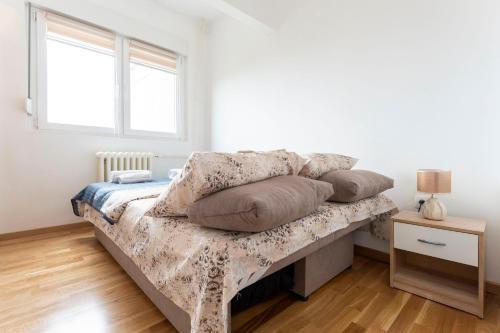 ein Schlafzimmer mit einem Bett mit Kissen darauf in der Unterkunft Aurora Apartman in Novi Beograd