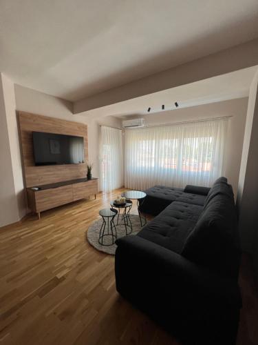 a living room with a black couch and a flat screen tv at Apartment33 in Strumica