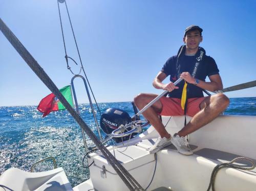 a man sitting on a boat in the ocean at VRS - 21FT BOATEL AFURADA in Vila Nova de Gaia