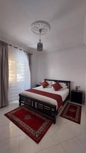 a bedroom with a bed with two rugs on it at Emplacement idéal in Tangier