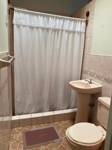y baño con ducha, aseo y lavamanos. en Casa Mafaldo en Iquitos