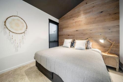 a bedroom with a large bed and a wooden wall at Laneway Retreat in Grange