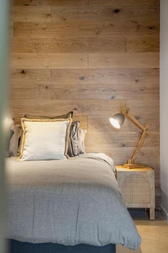a bedroom with a bed with a wooden wall at Laneway Retreat in Grange
