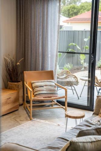 a living room with a chair and a balcony at Laneway Retreat in Grange