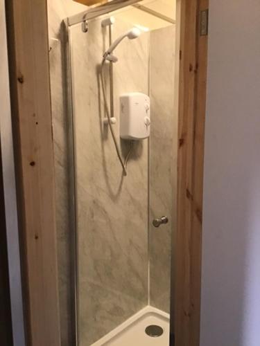 a shower with a glass door in a bathroom at Highlander Hostel in Kyle of Lochalsh