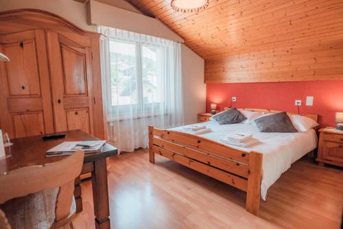 1 dormitorio con 1 cama grande y techo de madera en Relais Fleuri, en Chermignon-dʼen Bas