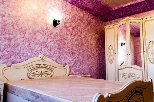 a bedroom with a bed and a pink wall at One-of-a-kind Home with a Million Dollar View in Yerevan