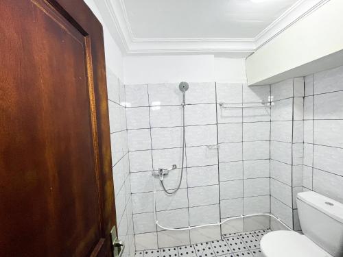 uma casa de banho com um chuveiro e um WC. em Studio Cosy centre AKWA em Douala