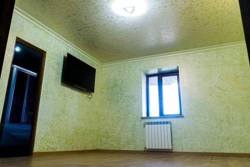 an empty room with a television and a window at One-of-a-kind Home with a Million Dollar View in Yerevan