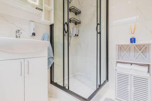 a white bathroom with a shower and a sink at Baila Casa apartments in Nottingham