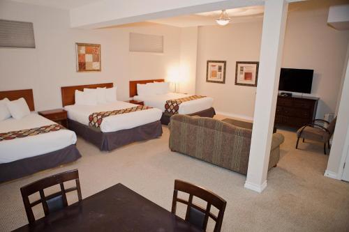 a hotel room with two beds and a couch at Super 8 by Wyndham Cochrane in Cochrane