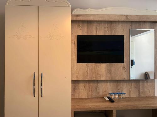 a cabinet with a television on top of it at Akkan Beach Hotel in Bodrum City