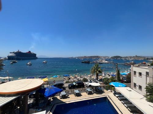 a view of a beach with a cruise ship in the water at Akkan Beach Hotel in Bodrum City