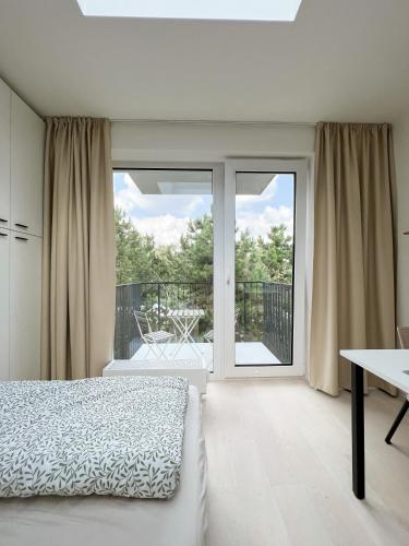 Habitación blanca con cama y balcón. en Celestial Apartments Brno, en Brno