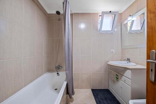 La salle de bains est pourvue d'une baignoire et d'un lavabo. dans l'établissement Ficcus Home, à Caniço