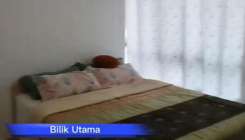 a bedroom with a bed and a window with a curtain at DD Homestay in Papar