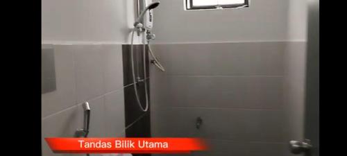 a shower stall in a bathroom with a red sign at DD Homestay in Papar