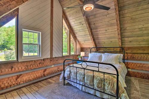 a bedroom with a bed in a room with wooden walls at Creekside cabin w/ hot tub, fireplace & trail in Newland