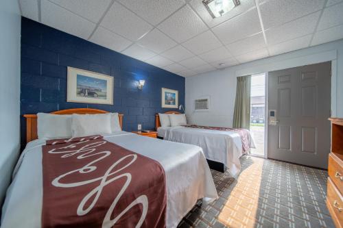 a hotel room with two beds and blue walls at Sleep-ees Inn in Shields