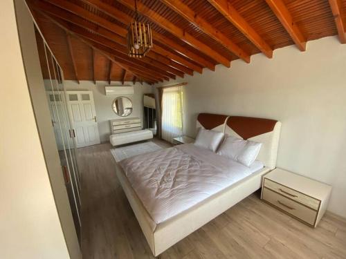 1 dormitorio con 1 cama grande y espejo en Villa Megara; Havuzlu Müstakil Villa en Kandıra