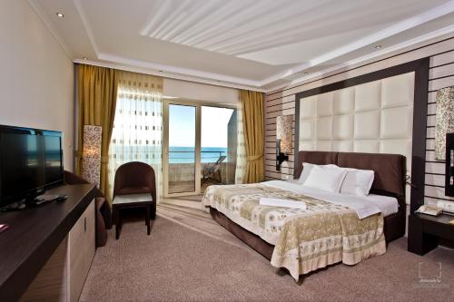 a hotel room with a bed and a television at Grand Hotel Pomorie in Pomorie