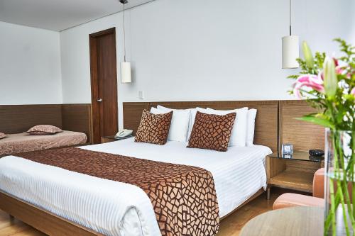 Hotel Poblado Alejandria في ميديلين: غرفة فندقية بسرير كبير وطاولة