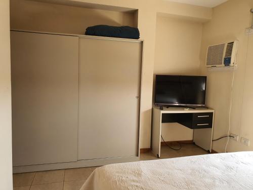 a bedroom with a bed and a tv and a closet at Altos Resistencia in Resistencia