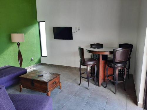 sala de estar con mesa, sillas y sofá en Casa GaTo Tequisquiapan, en La Tortuga