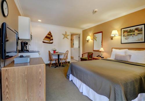 韋爾斯的住宿－Sea Mist Resort Motel，酒店客房设有一张大床和一张桌子。