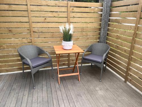 two chairs and a table with a potted plant on a patio at Right on Tyne in Oamaru