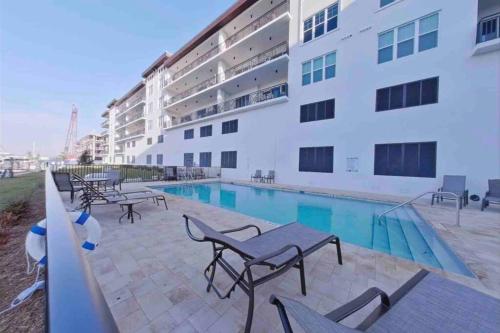 un hotel con piscina y sillas y un edificio en 5 Star Luxury Beach Condo-Anchor Oasis en St Pete Beach