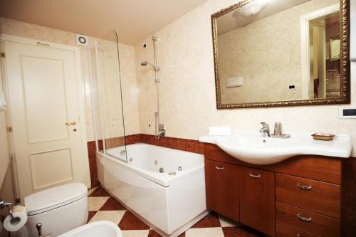 a bathroom with a tub and a sink and a toilet at Residence Odoni in Venice