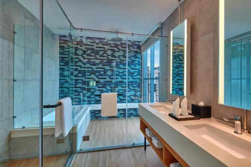 吉隆坡的住宿－Fairfield by Marriott Chow Kit Kuala Lumpur，带浴缸、水槽和镜子的浴室