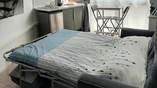 un lit d'hôpital avec couverture dans une pièce dans l'établissement Studio à 2 pas de la plage, à Marseille