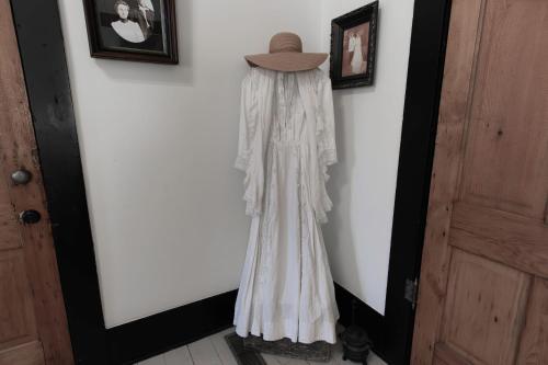 a dress hanging on a wall with a hat on it at Beard and Lady Inn in Chester