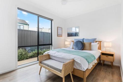 a bedroom with a bed and a large window at Seascape Christies Ocean Views in Christies Beach