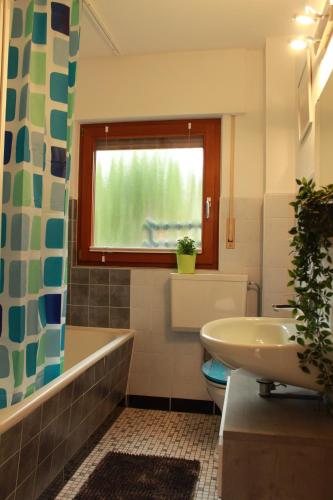 La salle de bains est pourvue d'une baignoire, d'un lavabo et d'une fenêtre. dans l'établissement Ferienwohnung CONNI, à Hellenthal