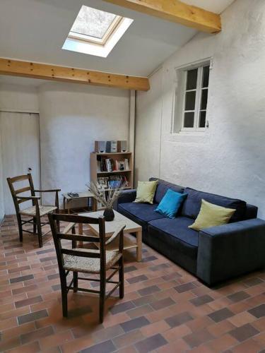 un salon avec un canapé bleu et une table dans l'établissement Maison proche rivière - 6 à 8 personnes, à Chambonas