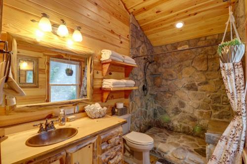 baño con aseo y lavamanos en una cabaña de madera en Romantic Mountain View Cabin Rental Near Downtown!, en Mountain View