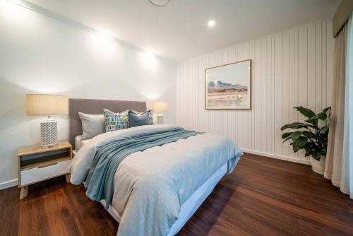 a bedroom with a bed and a potted plant at La Brisa Waterfront Family Home Beach WiFi in Grange