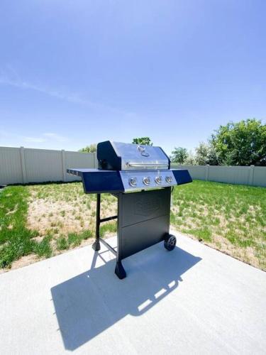 a blue barbecue grill sitting in a yard at BRAND NEW 4-BDRM HOME Farmhouse at Grand Rapids in Meridian