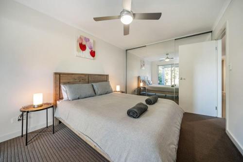 ein Schlafzimmer mit einem großen Bett und einem Deckenventilator in der Unterkunft Beach Haven at Semaphore in Port Adelaide